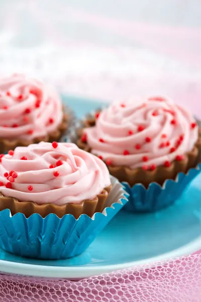 Polvilhas vermelhas em bombons de chocolate de cupcake rosa — Fotografia de Stock