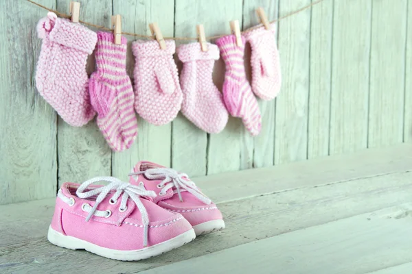 Sapatos de criança rosa no fundo verde claro de madeira — Fotografia de Stock