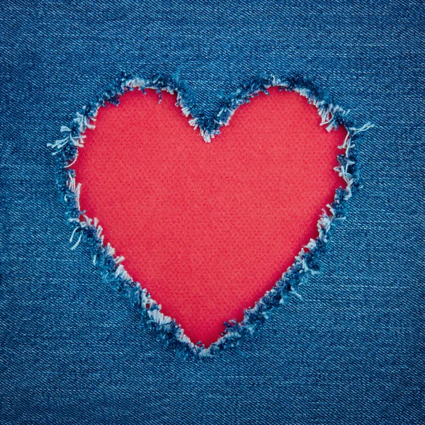 Fondo denim azul con corazón rojo — Foto de Stock