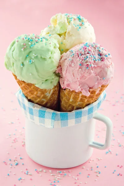 Conos de helado sobre fondo rosa espolvorear — Foto de Stock