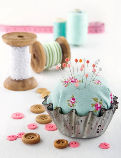 Floral pincushion in an old metal cupcake — Stock Photo, Image