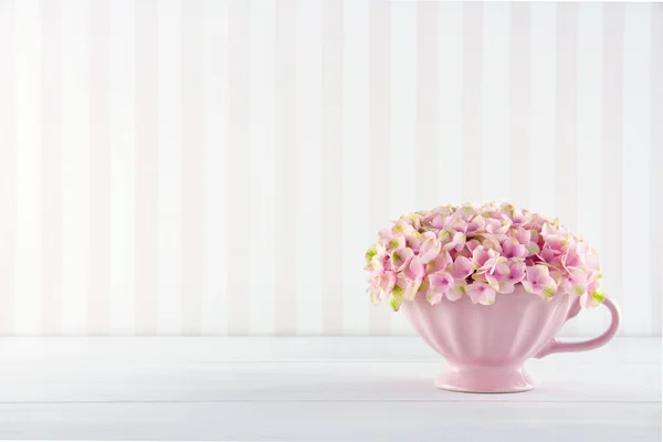 Blumen in einem schäbigen schicken Becher — Stockfoto