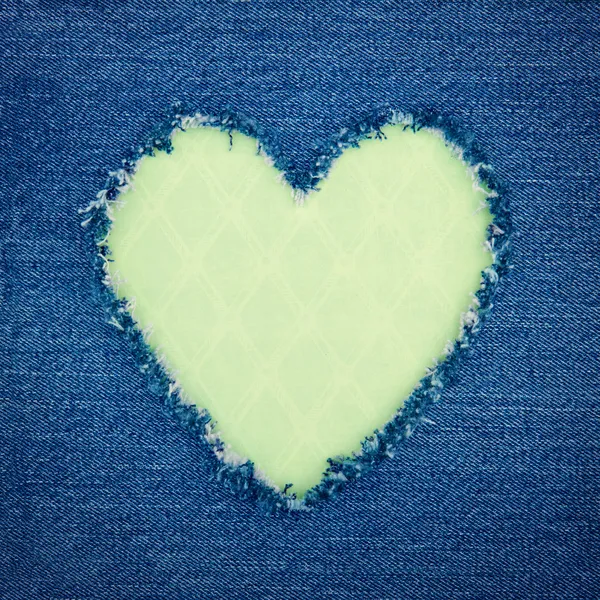 Green vintage heart on blue denim fabric — Stock Photo, Image