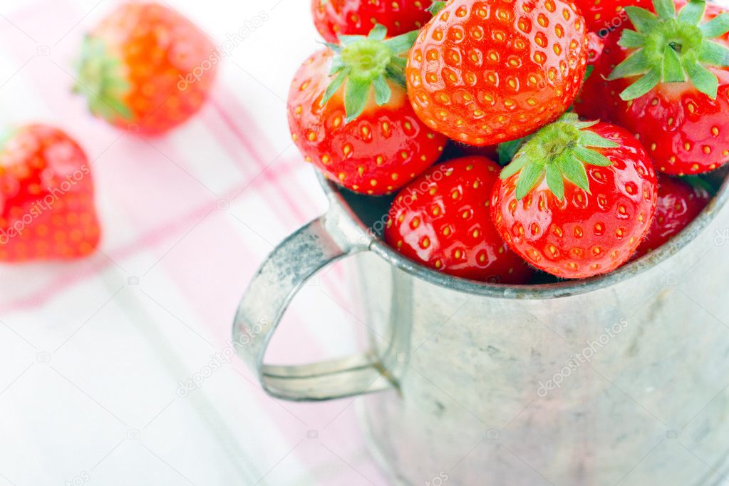 Strawberries in an old metal measurement cup