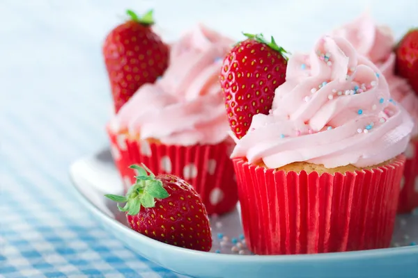 Cupcakes com morangos e polvilhas coloridas — Fotografia de Stock