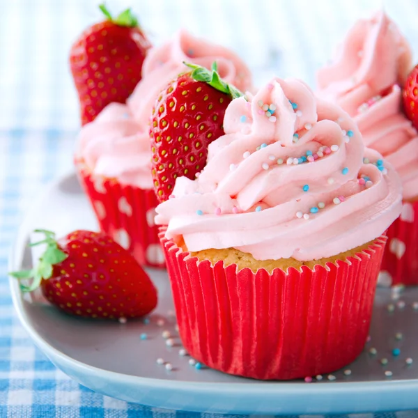 Cupcakes cor-de-rosa com morangos frescos e polvilhas — Fotografia de Stock