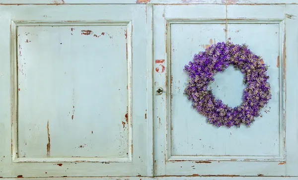 Lavendel blomst krans hængende på en gammel dør - Stock-foto