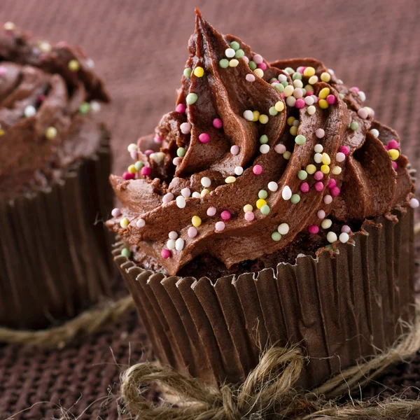 Cupcakes with colorful sprinkles on dark background — Stock Photo, Image