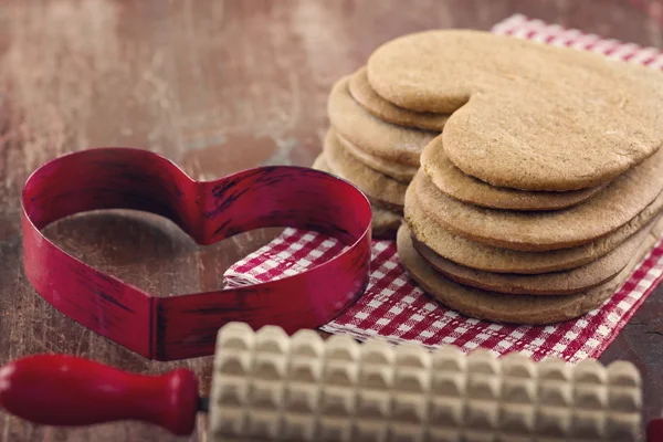 Heart shaped cookie cutter and a homemade Christmas gingerbreads — Stock Photo, Image