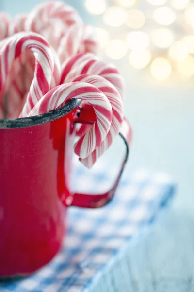 Rot gestreifte Zuckerstangen in einem roten Becher — Stockfoto