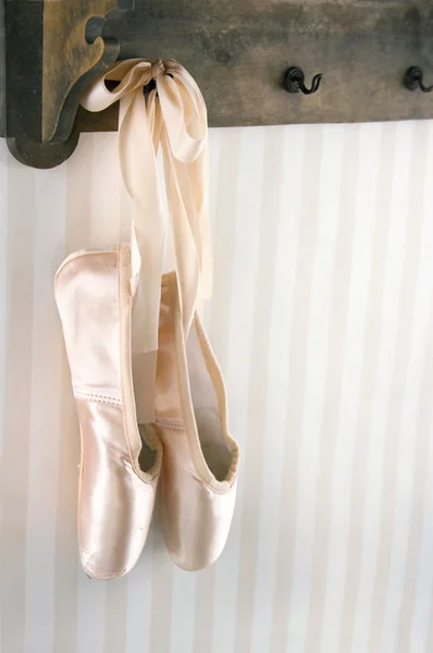 Ballet pointe shoes hanging from wooden rack — Stock Photo, Image