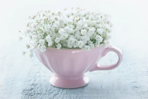 Pink cup with white flowers — Stock Photo, Image