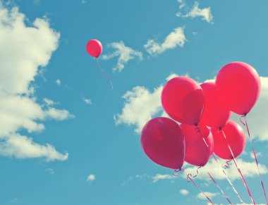 Bunch of red ballons on a blue sky clipart