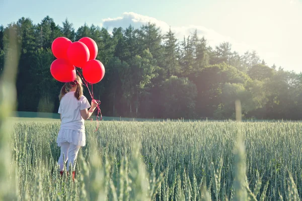 Meisje met een bos van rode ballonnen — Stockfoto