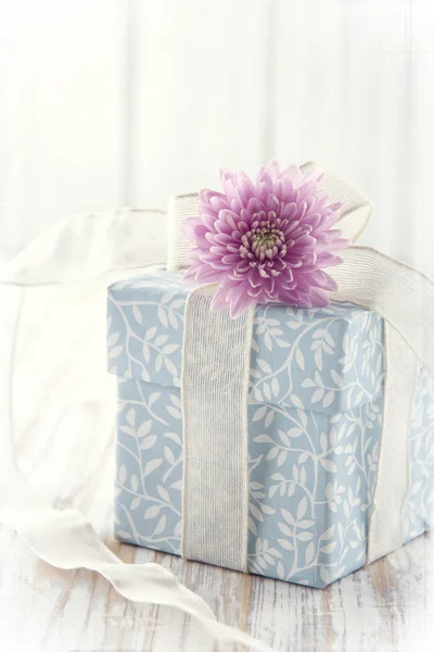 Голубая подарочная коробка с цветами, перевязанная белой лентой — стоковое фото