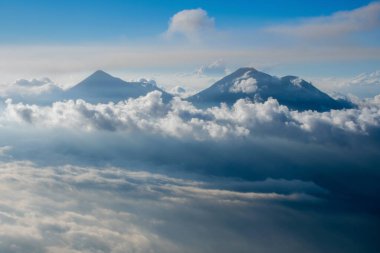 Bulutlarda iki volkan. Volkan de Fuego ve Volkan Acatenango 'nun Volkan de Agua' nın tepesinden görünüşü.