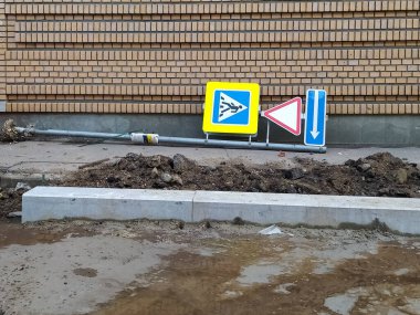 Yol yüzeyinin tamiri, kaldırımların değiştirilmesi. Kaldırımda yol işaretleri olan bir direk var. Her şey çıkarıldı..