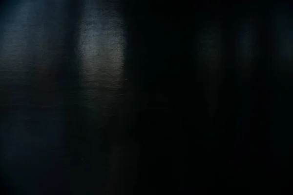 Czarna drewniana powierzchnia malowana farbą. Plamy światła i cienia na powierzchni tła — Zdjęcie stockowe
