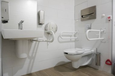 Engelliler için umumi tuvalet. Özel tırabzanlar ve klinik personeli için acil çağrı düğmesi