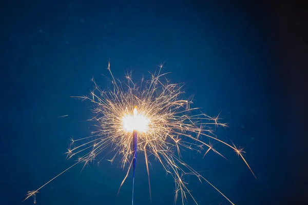 Burning sparkler fireworks on a dark blue background. Christmas and festive concept of the event. Fireshow — Fotografia de Stock