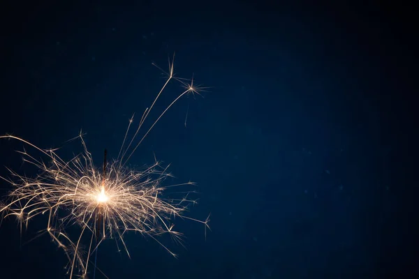 Burning sparkler fireworks on a dark blue background. Christmas and festive concept of the event. Fireshow — Fotografia de Stock