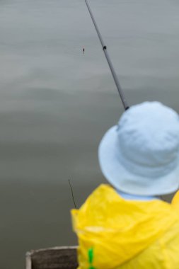 Olta kamışlı bir çocuk. Göl veya göl suyunun yüzeyinde bir şamandıra. Metin için boşluk