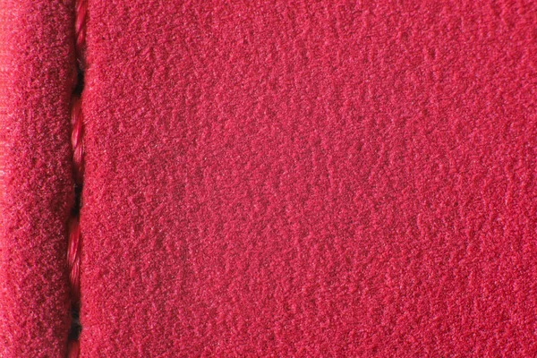 Part of the surface of a red fabric with a seam. — Stock Photo, Image