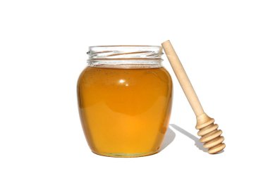 Kavanozda taze bal, beyaz izole bir zemin üzerinde ahşap bir kepçeyle..
