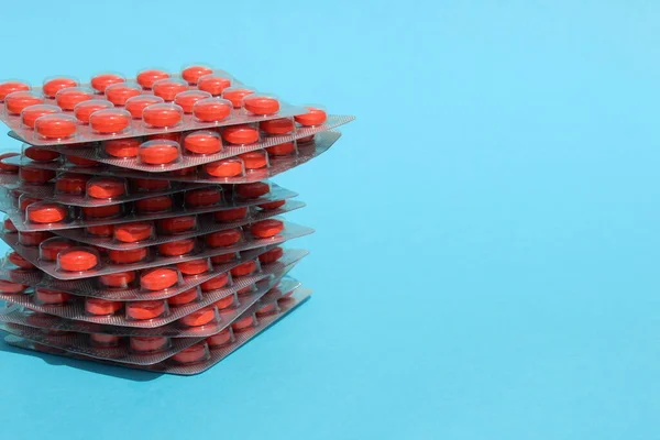 Pastillas Rojas Paquete Encuentran Una Pila Sobre Fondo Azul —  Fotos de Stock