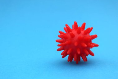 Mavi arkaplanda metin için yeri olan koronavirüsün kırmızı modeli.