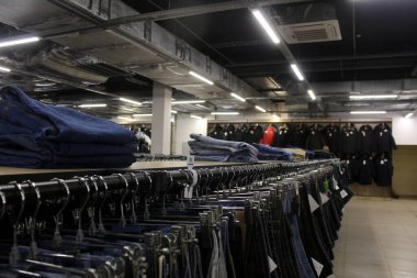 Kıyafetlerle alışveriş merkezi. Kotlar pencerede asılı..