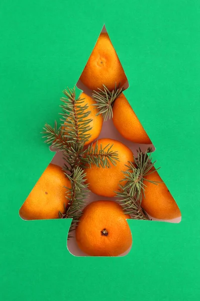 圣诞树的形状是从纸上剪下来的 橘子放在树的底部 — 图库照片