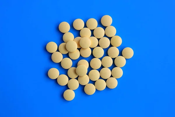 Sárga Tabletták Fekszenek Egy Halom Kék Háttér — Stock Fotó