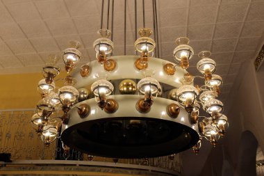 Tavanda büyük bir klasik avize asılı..