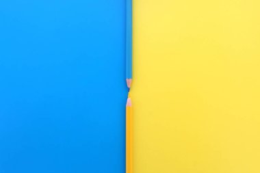 Mavi ve sarı arka planda, aynı renkte iki kalem, metin için boşluk ile aynı anda yatar..