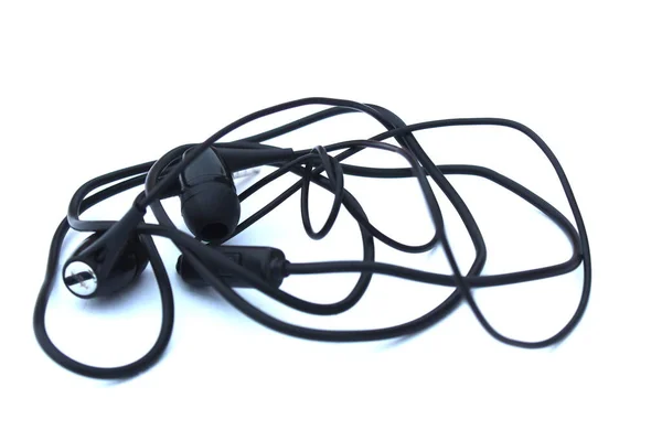 Μπλεγμένα Μαύρα Ακουστικά Βρίσκονται Λευκό Φόντο — Φωτογραφία Αρχείου