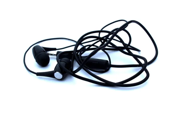 Auriculares Negros Enredados Yacen Sobre Fondo Blanco — Foto de Stock