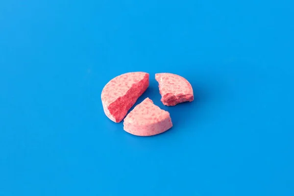 Egy Törött Rózsaszín Tabletta Fekszik Kék Háttér — Stock Fotó