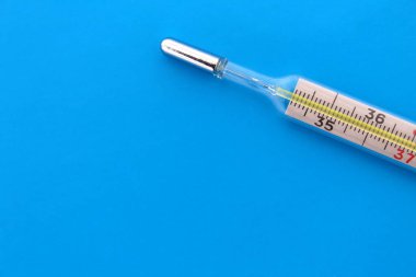 Termometre, metin için bir yeri olan mavi bir arkaplanda yatar.