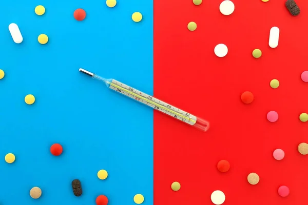 Термометр Лежит Красных Синих Цветах Окружении Таблеток — стоковое фото