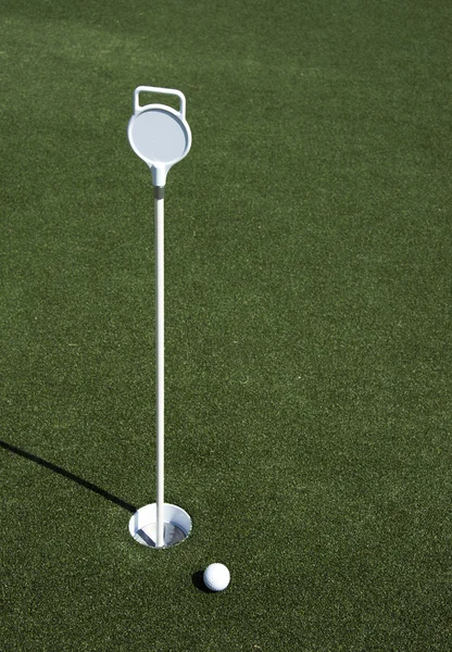 Golf ball and hole on a field