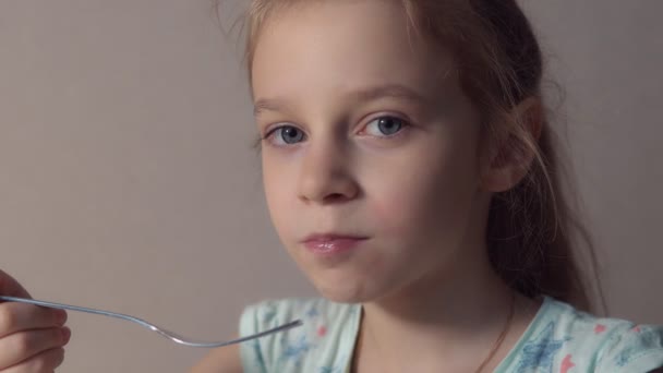 Petite fille mangeant du kiwi avec une fourchette. Une alimentation saine Vidéo De Stock