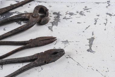 Gri bir demir zemin üzerinde eski paslı inşaat aletleri 