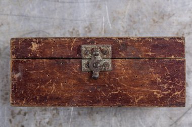 Gri demir bir masa üzerinde demir kilidi olan eski, eski bir tahta kutu. 