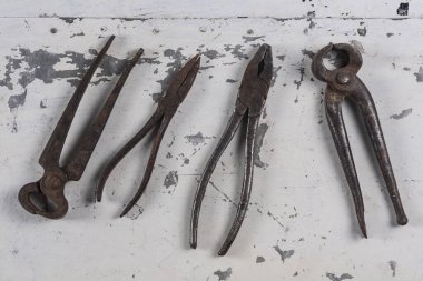 Gri bir demir zemin üzerinde eski paslı inşaat aletleri 