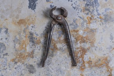 Gri bir demir zemin üzerinde eski paslı inşaat aletleri 