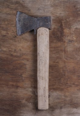 Eski balta, kahverengi tahta bir masada ağaç kesmek için bir araçtır.