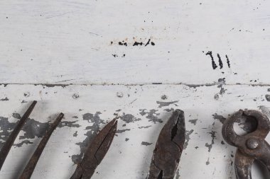 Gri bir demir zemin üzerinde eski paslı inşaat aletleri 