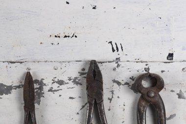 Gri bir demir zemin üzerinde eski paslı inşaat aletleri 