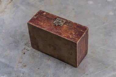 Gri demir bir masa üzerinde demir kilidi olan eski, eski bir tahta kutu. 